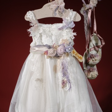 Ένα ρομαντικά διακοσμημένο σύνολο για κορίτσι  που περιλαμβάνει: Φόρεμα (φόδρα από 100% βαμβάκι) με συνδυασμό από δαντέλες, τούλι και χειροποίητα υφασμάτινα λουλούδια Στεφάνι ασορτί Μπαλαρίνες με κορδέλα σε φλοράλ ύφασμα Για να ντύσει στιγμές αγάπης και ευτυχίας!